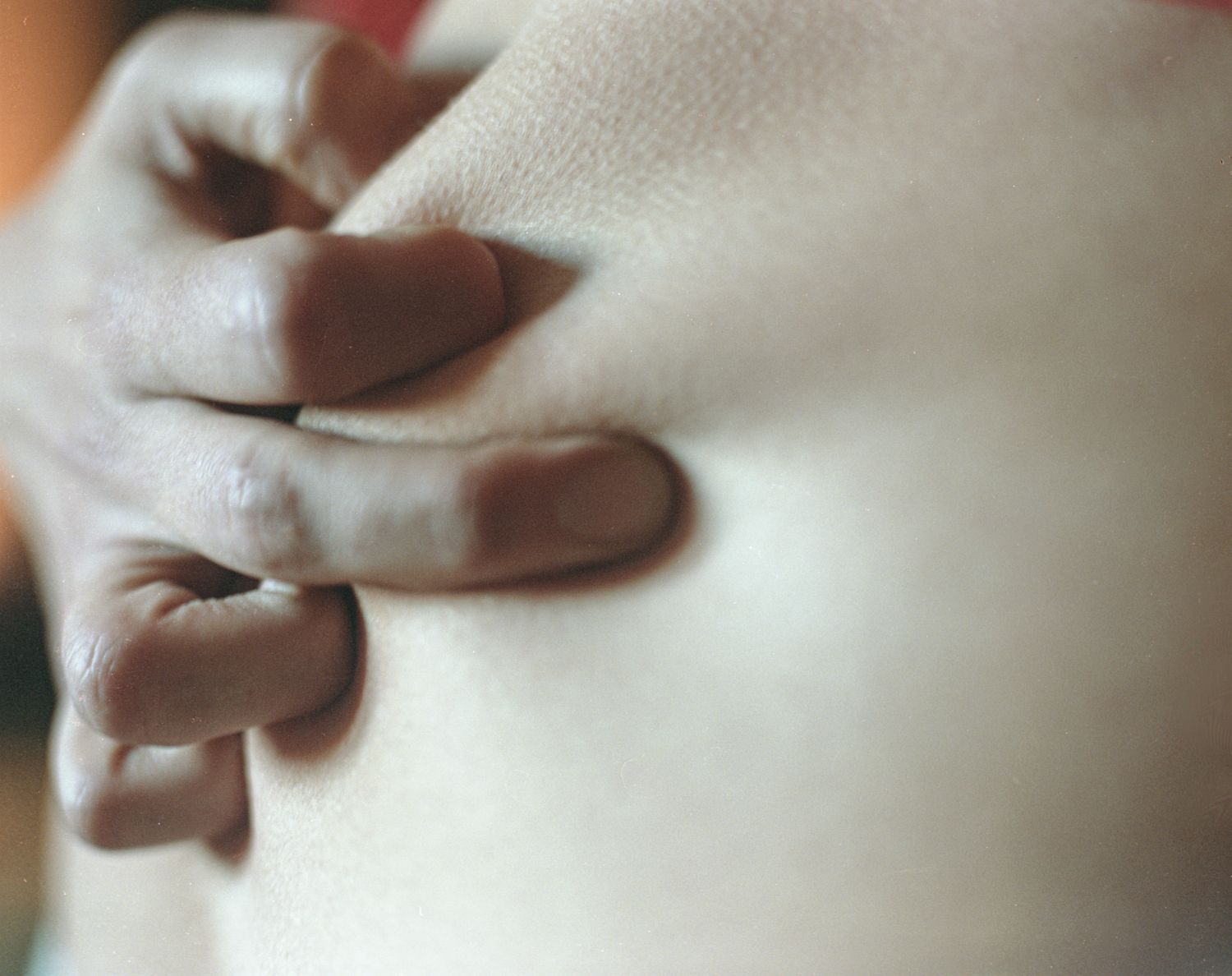 A hand pressing into pale fabric
