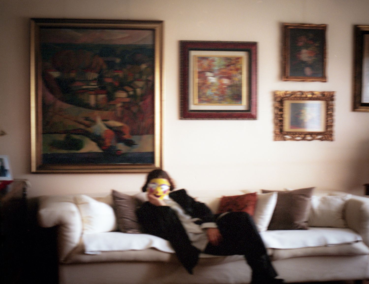 A masked figure lying on a sofa