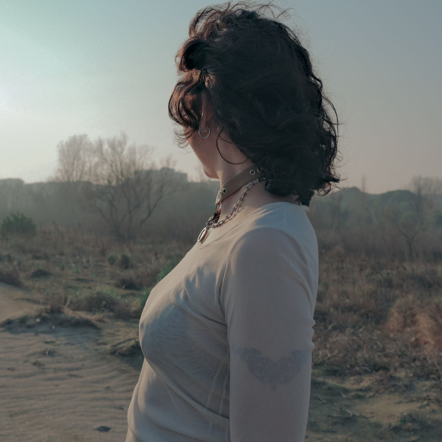 A person seen from the side in a dry landscape