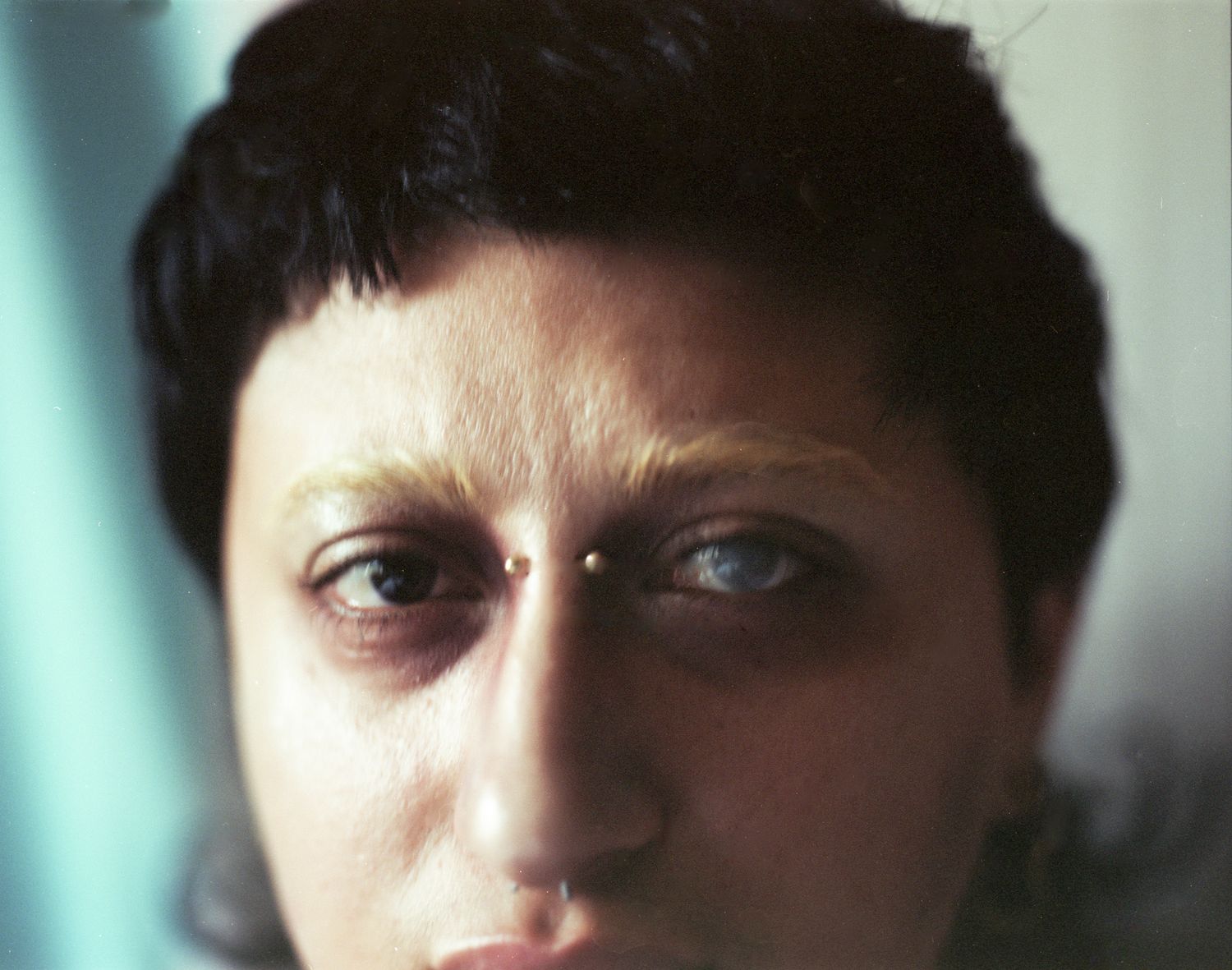 Extreme close-up of eyes of two different colours, with a piercing