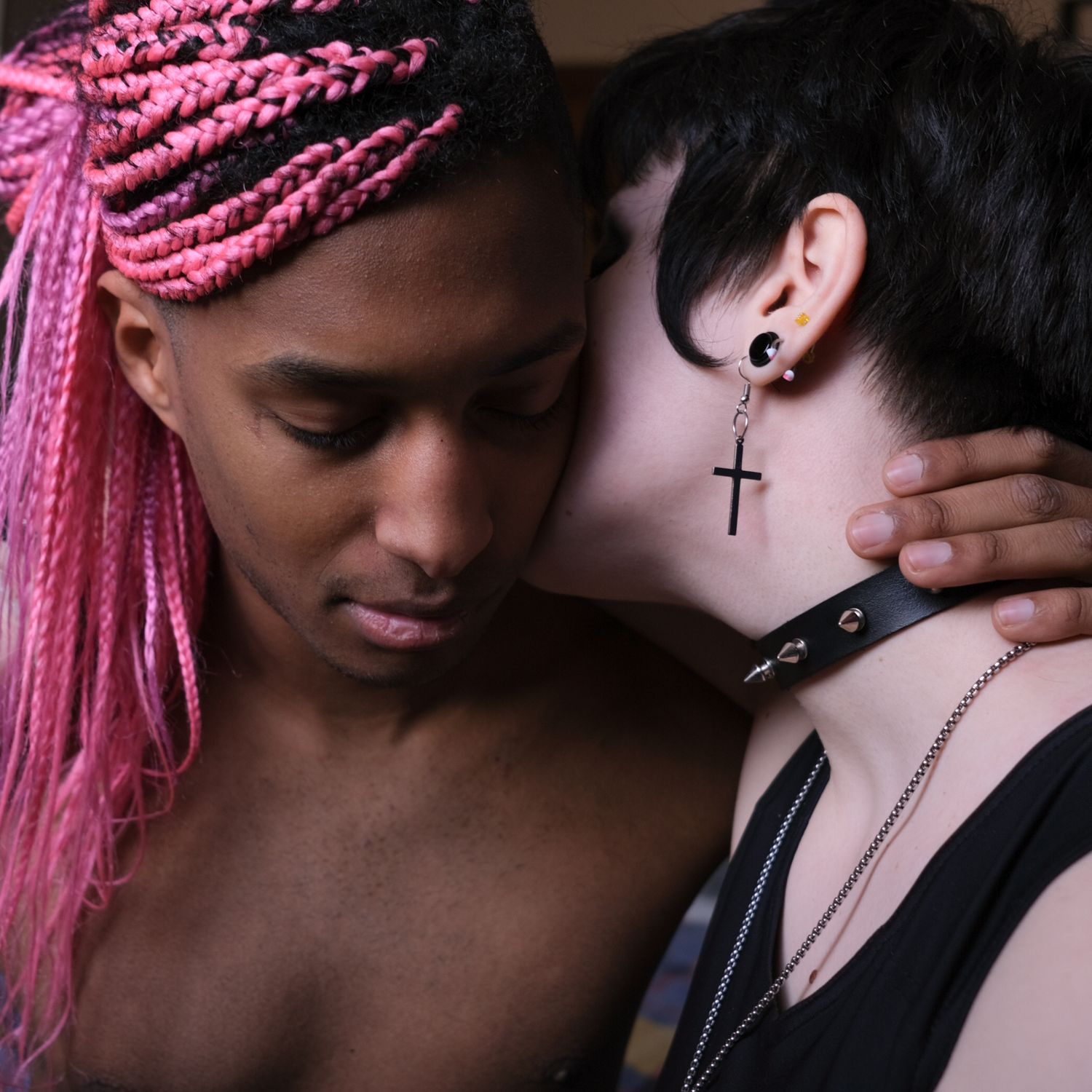 Two people embracing, one with pink braids
